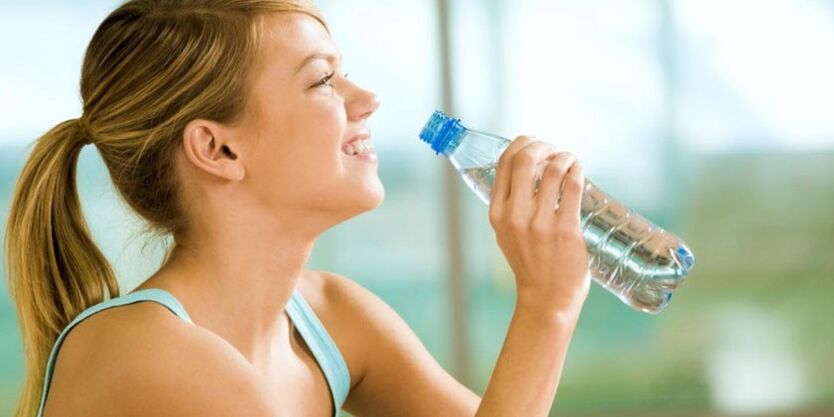 Девушка пьет воду, чтобы похудеть