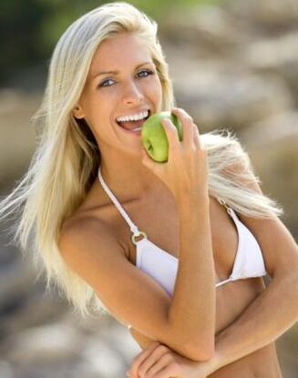 Девушка ест яблоко в месяц, чтобы похудеть на 10 кг